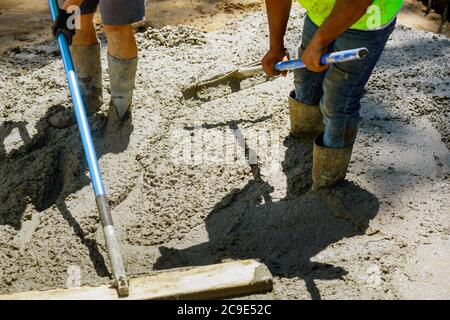 Baumörtel Bau einer Estrich Zement ein Arbeiter schwimmt einen neuen Betonweg Stockfoto