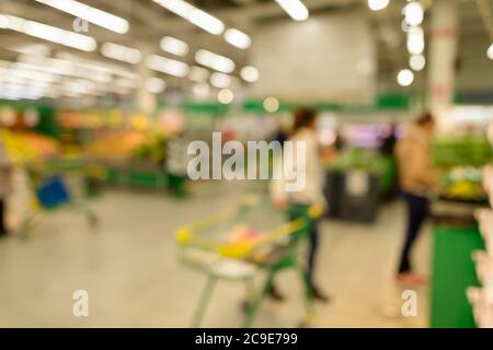 Verschwommene Kunden einkaufen für Lebensmittel im Supermarkt mit einer Vielzahl von Produkten in den Regalen geladen Stockfoto