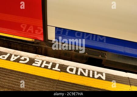 Ein Zug wird eine UK-Plattform, malte "Mind the Gap" Warnzeichen. Stockfoto