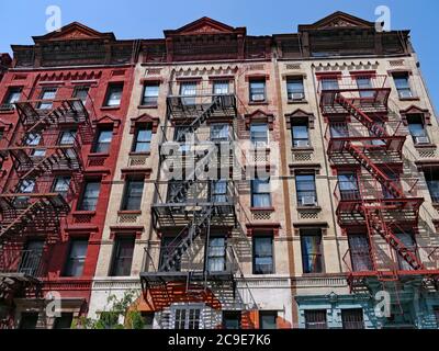 New York City, farbenfrohe, altmodische Wohnhäuser mit externen Feuerleitern Stockfoto