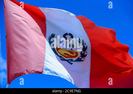 Peruanische Flagge weht im Wind mit blauen Himmel im Hintergrund Stockfoto