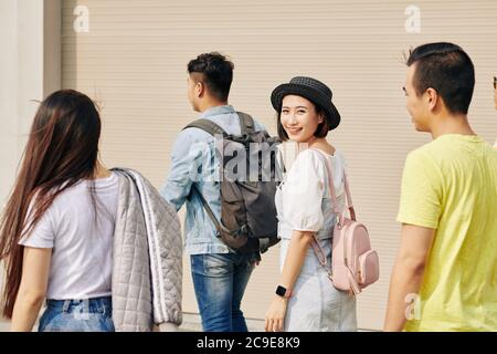 Schöne junge Vietnamesin in kleinem Hut, die zur Universitätsklasse geht Stockfoto