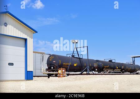 Bartlett, Illinois, USA. Eisenbahnkesselwagen ruhen auf einem Bahngleis, der eine Produktionsanlage innerhalb eines Industriepark-Komplexes bedient. Stockfoto