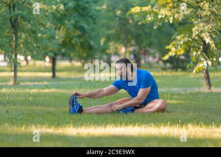 Der Mensch dehnt sich im Sommer im Freien aus. Das Konzept eines aktiven Lebensstils und eines gesunden Lebensstils im Alter nach 40 Jahren. Stockfoto