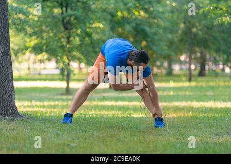 Mann, der sich aufwärmt, bevor er im Sommer im Freien joggt. Das Konzept eines aktiven Lebensstils und eines gesunden Lebensstils im Alter nach 40 Jahren. Stockfoto