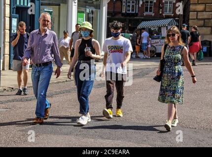 Cambridge, Großbritannien. Juli 2020. Ein Familienspaziergang entlang der Marktstraße mit ihren beiden Kindern, die Gesichtsmasken tragen, als vorbeugende Maßnahme. Die Menschen tragen eine Vielzahl von Gesichtsmasken im Freien in Cambridge, obwohl sie im Moment in Großbritannien nur auf öffentlichen Verkehrsmitteln und in Geschäften und öffentlichen Räumen vorgeschrieben sind. Kredit: SOPA Images Limited/Alamy Live Nachrichten Stockfoto