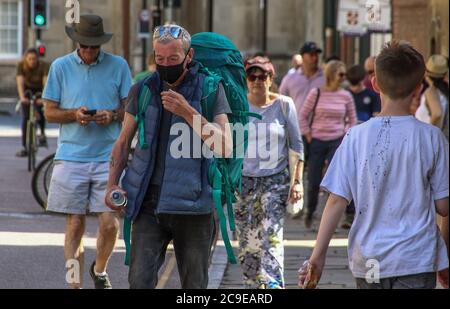 Cambridge, Großbritannien. Juli 2020. Ein Mann, der eine Gesichtsmaske als vorbeugende Maßnahme trägt, geht auf der Straße. Die Menschen tragen eine Vielzahl von Gesichtsmasken im Freien in Cambridge, obwohl sie im Moment in Großbritannien nur auf öffentlichen Verkehrsmitteln und in Geschäften und öffentlichen Räumen vorgeschrieben sind. Kredit: SOPA Images Limited/Alamy Live Nachrichten Stockfoto