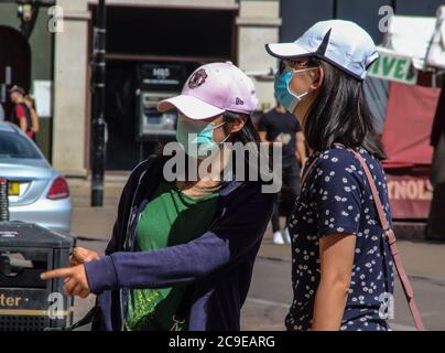 Cambridge, Großbritannien. Juli 2020. Zwei Frauen, die Gesichtsmasken als vorbeugende Maßnahme tragen, werden beim Einkaufen im Freien inmitten der Coronavirus-Krise gesehen. Die Menschen tragen eine Vielzahl von Gesichtsmasken im Freien in Cambridge, obwohl sie im Moment in Großbritannien nur auf öffentlichen Verkehrsmitteln und in Geschäften und öffentlichen Räumen vorgeschrieben sind. Kredit: SOPA Images Limited/Alamy Live Nachrichten Stockfoto