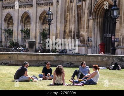 Cambridge, Großbritannien. Juli 2020. An einem warmen Sommertag sitzen die Leute auf dem Rasen vor dem Haupteingang des Kings College, Teil der Cambridge University. Die Menschen entspannen sich während des warmen Sommerwetters, da die Temperatur in England voraussichtlich bis zum Wochenende 30 Grad Celsius erreichen wird. Kredit: SOPA Images Limited/Alamy Live Nachrichten Stockfoto