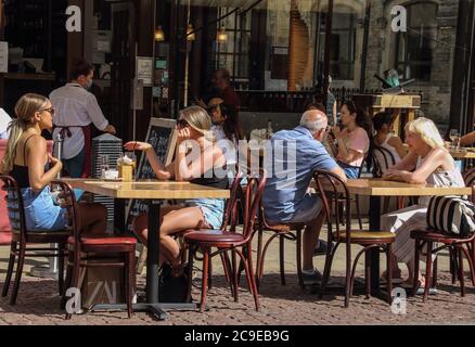 Cambridge, Großbritannien. Juli 2020. An einem warmen Sommertag sitzen die Leute in einem Restaurant im Stadtzentrum. Die Menschen entspannen sich während des warmen Sommerwetters, da die Temperatur in England voraussichtlich bis zum Wochenende 30 Grad Celsius erreichen wird. Kredit: SOPA Images Limited/Alamy Live Nachrichten Stockfoto