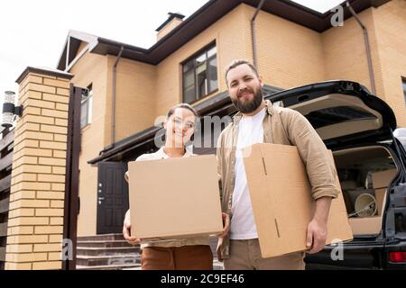 Portrait von positiven jungen Paar haben von Traum Haus stehend mit beweglichen Boxen gekauft Stockfoto