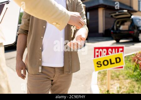 Close-up von nicht erkennbaren makler geben Hausschlüssel für neue Besitzer nach der Unterzeichnung des Kaufvertrages Stockfoto