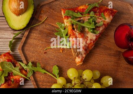 Flat Lay close up Bild von hausgemachten vegetarischen Käse und Tomate Pizza mit frischen Rucola Blätter und gegrillten Eierpflanzen Scheiben dekoriert. Es ist Serv Stockfoto