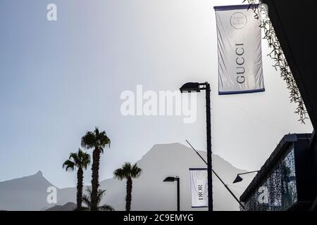 Hinterleuchtete Stoffbanner, die Luxusmarken auf Lampfosten vor dem Einkaufszentrum Plaza del Duque, Costa Adeje, Teneriffa, Kanarische Inseln, werben Stockfoto