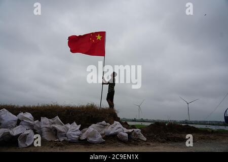 Peking, Juli 16. Juli 2020. Ein Mitarbeiter richtet die Nationalflagge vor einem Hochwasserkontrollposten in Jiujiang, ostchinesische Provinz Jiangxi, am 16. Juli 2020. UM MIT DEN XINHUA SCHLAGZEILEN VOM 31. JULI 2020 ZU GEHEN. Quelle: Zhou Mi/Xinhua/Alamy Live News Stockfoto