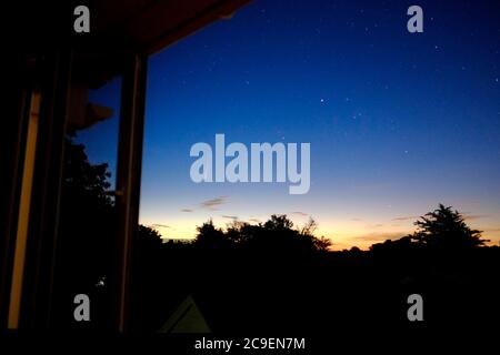 NEOWISE Komet im Morgenhimmel mit Blick auf das Schlafzimmer Fenster bei Tagesanbruch Stockfoto