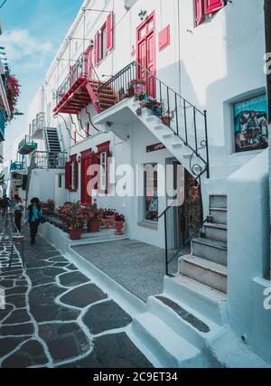 Bunte Häuser und Handel auf blau-weißen Farben mit Blumen in der Altstadt von Mykonos Island, Griechenland. Stockfoto
