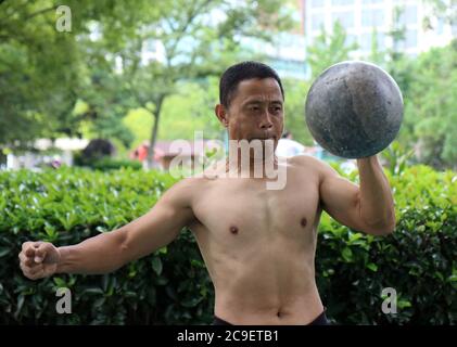 31. Juli 2020, Huaian, Huaian, China: JinagsuÃ¯Â¼Å'CHINA-am 26. Juli 2020 zeigen Bodybuilding-Enthusiasten ihre einzigartigen Fähigkeiten in der Ecke des Grand Canal Square. Es gibt mehr als 50 Menschen in Huai 'an Stadt, Jiangsu Provinz Steinschleusenverband, die meisten der Mitglieder sind über 50 Jahre alt, Aber alle haben ''einzigartige Fähigkeiten'', Dutzende von Pfund Steinschloss in ihren Händen als Spielzeug in der allgemeinen flexiblen ''Fliegen''', werfen, fangen, heben und andere Bewegungen geschickt. Steinschloss ist eine Art von körperlicher Bewegung, in den letzten Jahren mit der Entwicklung von Massensport, Steinschloss und wieder steigen. (Cr Stockfoto