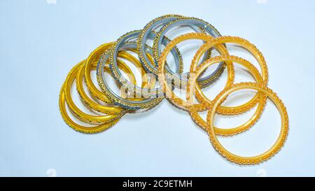 Goldene, blaue und gelbe Farbe Glas und Metall-Armreifen auf weißem Hintergrund. Stockfoto