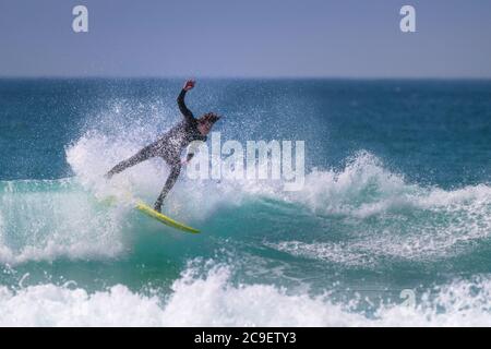 Wilde spektakuläre Action als Surfer reitet eine Welle am Fistral in Newquay in Cornwall. Stockfoto