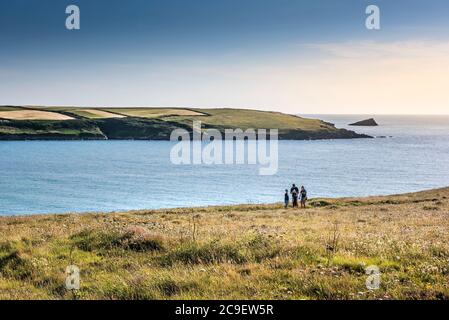 Eine Familie von Urlaubern auf dem Küstenweg auf Ganze Point East mit Blick auf das Meer bei Crantock in Newquay in Cornwall. Stockfoto