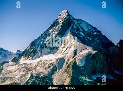 Dieses Panorama von Schönbiel blickt auf die Nordwand des Matterhorn-Kults mit links der Hoernli-Ridge-Szene der Erstbesteigung am 15. Juli 1865 eine Expedition unter der Leitung von Britisher Edward Whymper, als einige seiner Gruppen in der Nähe des Gipfels fielen Die gesamte Länge der Nordwand [Mitte]. Der Zmutt Grat durchbricht den Mittelgrund, während der Italianergrat das richtige Profil einnimmt. Der Berg ist das Leben und die Seele des Schweizer Bergurlaubsortes Zermatt im Schweizer Kanton Wallis, wie es 2000 war. Stockfoto