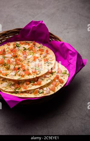 Masala Papad oder Papadum ist ein köstlicher indischer Snack, der aus gerösteten oder gebratenen Papaden mit einer würzigen Zwiebeltomate-Mischung garniert wird Stockfoto