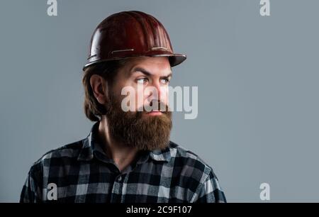 Selbstbewusster Mechaniker. Bärtiger Mechaniker. Selbstbewusster Bauingenieur. Professioneller Architekt. Reparatur oder Gebäude. Verantwortlich für die Sicherheit. Seriöser männlicher Arbeiter trägt einen Hut. Brutaler Baumeister im Helm. Stockfoto