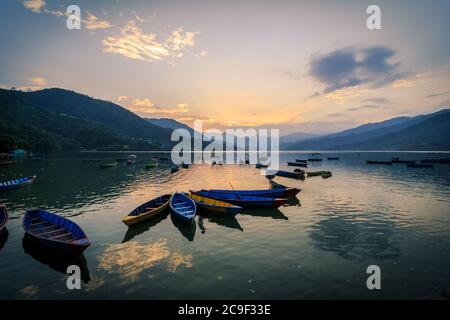 Sonnenuntergang am Ufer des Phewa Sees mit bunten Booten in Pokhara, Nepal. Stockfoto