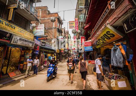 Unbekannte Menschen, die durch die bunten Straßen des Viertels Thamel in Kathmandu, Nepal, wandern Stockfoto