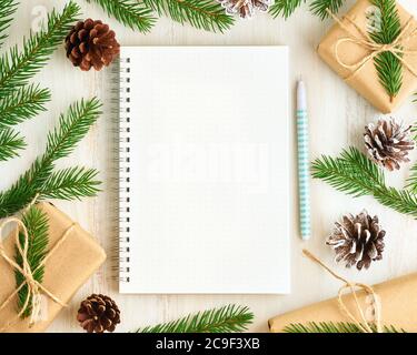 Weißer offener Notizblock, Bullet Journal und Weihnachtsdekoration auf weißem Holzhintergrund liegend, flaches Lay, Copyspace. Handgefertigt, Kunststoff frei, Null Stockfoto