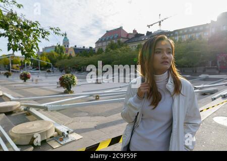 Junge schöne asiatische touristische Frau denken in leeren Stadtplatz im Freien Stockfoto