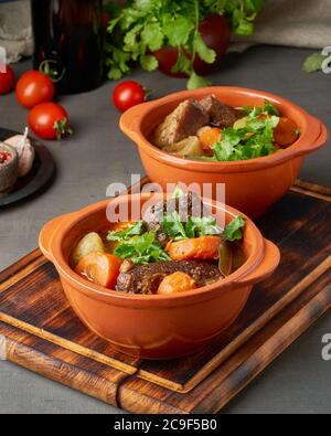 Burgunderfarbenes Fleisch. Langsames Einkochen, Kochen in zwei Topf oder Gusseisen Pfanne. Stockfoto
