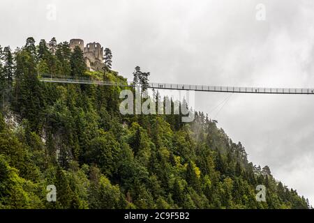 Die Hochline179-Fußgängerklammbrücke verbindet die Ruinen der Burg Ehrenberg mit dem gegenüberliegenden Fort Claudia nahe Reutte, Tirol, Österreich. Sie ist 406 Meter lang und überspannt das Tal in einer Höhe von bis zu 114 Metern. Von ihrer Eröffnung im Jahr 2014 bis 2017 hielt sie den Guinness-Weltrekord als längste Fußgängerklammbrücke der Welt. Sie ist nach der Bundesstraße 179 benannt, die unter ihr verläuft. Stockfoto