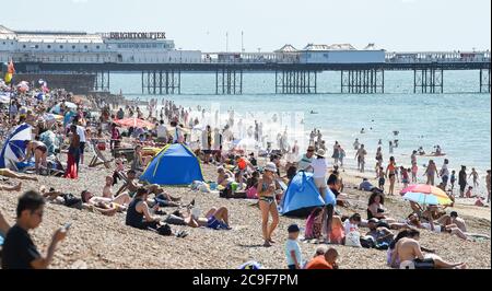 Brighton UK 31. Juli 2020 - die Massen strömen heute an dem Strand von Brighton an, der voraussichtlich der heißeste Tag des Jahres sein wird, mit Temperaturen, die im Südosten weit über 30 Grad erreichen werden. Das Wetter wird dann über das Wochenende abkühlen: Credit Simon Dack / Alamy Live News Stockfoto