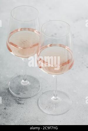 Zwei Gläser rosa Rose hausgemachten Sommer erfrischenden Wein auf hellem Stein Hintergrund. Stockfoto