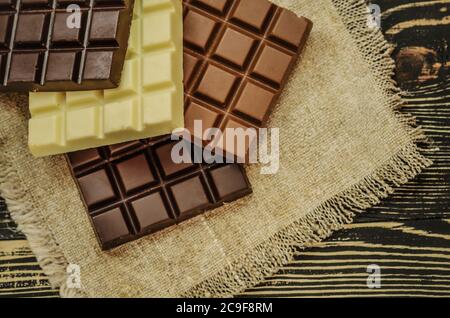 Gruppe von Schokoladen-Bars verschiedenen Farben. Verschiedene Arten von Süßigkeiten. Mischen Sie Schokoladentafeln in verschiedenen Farben und Typen. Stockfoto