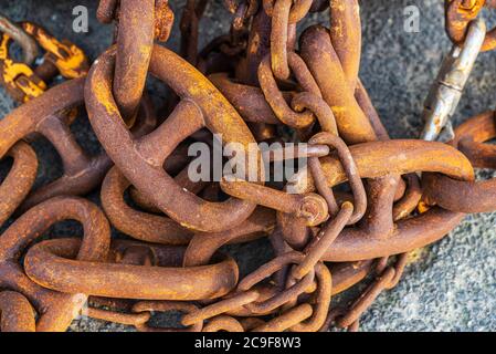 Haufen alter rostiger Metallketten, die als Hintergrund für die Fischerei im Hafen von Howth, Irland, verwendet wurden Stockfoto