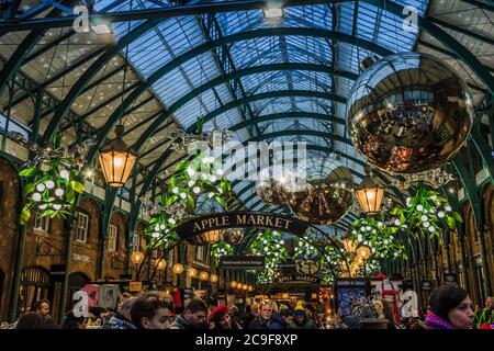 Covent Garden, London Apple Market zu Weihnachten mit Einkäufern im Vordergrund dekoriert Stockfoto