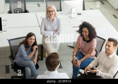 Fröhliche, vielfältige Kollegen, die Spaß am Business Briefing haben, Draufsicht Stockfoto