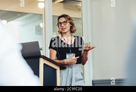 Geschäftsfrau, die während einer Konferenz eine Rede hält. Unternehmerin erklärt neues Projekt in einer Konferenz. Stockfoto