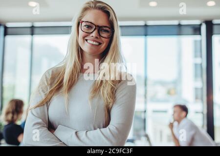 Porträt einer selbstbewussten Geschäftsfrau mit Kollegen im Sitzungssaal. Positive Frau mit Kollegen im Konferenzraum.