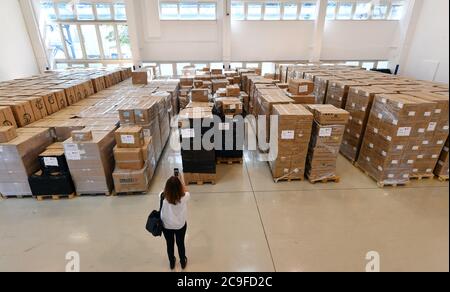 Erfurt, Deutschland. Juli 2020. Eine Frau fotografierte im Pandemielager in einem Lager des Deutschen Roten Kreuzes (DRK) Schutzausrüstung. Die Halle ist das zentrale Lager des Gesundheitsministeriums für persönliche Schutzausrüstungsmaterialien wie Masken, Kleider, Handschuhe, Brillen, Overalls und Schilde. Quelle: Martin Schutt/dpa-Zentralbild/dpa/Alamy Live News Stockfoto