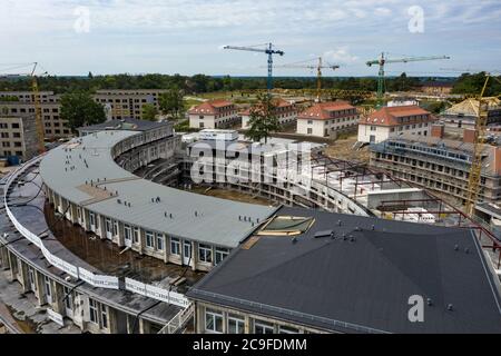 Elstal, Deutschland. Juli 2020. Blick auf die Gebäude, die auf dem Gelände des Olympischen Dorfes in Elstal in Brandenburg rekonstruiert werden (mit Drohne aufgenommen). Seit Januar 2019 saniert der Nürnberger Immobilienentwickler terraplan das denkmalgeschützte Speisehaus der Nationen inklusive des ehemaligen Kesselhauses, dem zukünftigen Haus Central. Darüber hinaus werden weitere neue Wohngebäude rund um diese Gebäude errichtet. Insgesamt werden in der ersten Bauphase bis 2022 rund 365 Wohnungen gebaut. Quelle: Paul Zinken/dpa-Zentralbild/ZB/dpa/Alamy Live News Stockfoto