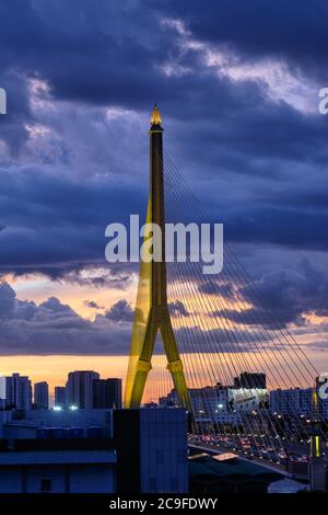 Beleuchtetes Rama VIII Brücke (Rama 8. Brücke), eine Hängebrücke über den Chao Phraya Fluss in Bangkok, Thailand, bei einem bunten Sonnenuntergang Stockfoto