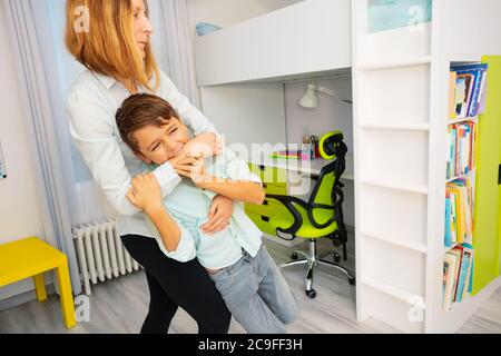 Close Portrait von kleinen autistischen Jungen beißen Hände mit starken negativen Gesichtsausdruck, werfen Tantrums Stockfoto