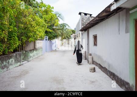 Nicht erkennbar Junge muslimische Frau in Sandstraße in Bodufolhudhoo Insel Dorf, Malediven Stockfoto