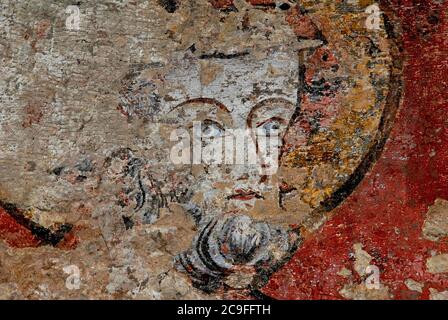 Fragmentarisches Gesicht mit auffallenden blauen Augen starrt von einem teilübermalten Fresko aus dem Jahr 1300s in der Chapelle des Fonts baptismaux, Cathédrale Saint-Pierre, in Beauvais, Frankreich. Stockfoto