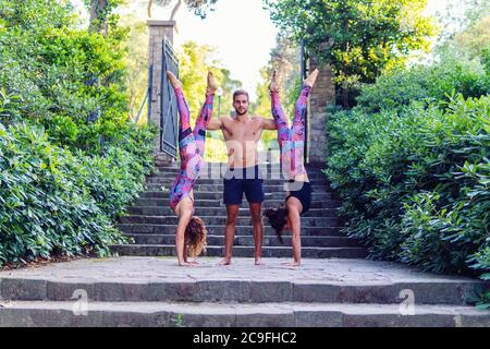 Schöner Mann und zwei Frauen üben acroyoga Stockfoto