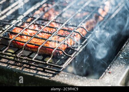 Saftige Scheiben von Fleisch mit Soße vorbereiten auf Feuer Stockfoto